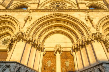 Dusk view of the Gothic Cathedral of Saint Mary and Saint Julian, with facade illuminated by warm light. It is a Catholic cathedral in the town of Cuenca, Castilla La Mancha, Spain