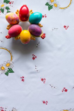 Beyaz masa örtüsü üzerinde renkli paskalya yumurtalarının üst görüntüsü