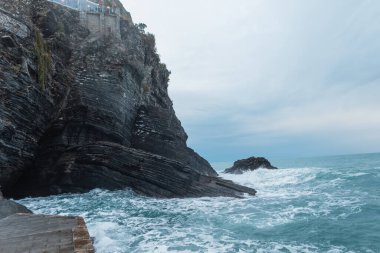 Beautiful rock near the sea with waves in Vernazza, Italy clipart