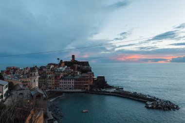 İtalya, Vernazza 'da gün batımından sonra deniz kenarında eski evleri olan inanılmaz güzel bir klasik kasaba.