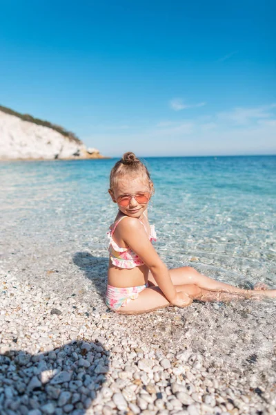 Beautiful Child Girl Sunglasses Sits Rest Beach Blue Clean Sea — Stock Photo, Image