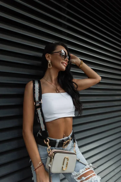 Mujer hipster joven estadounidense en gafas de sol de moda en una