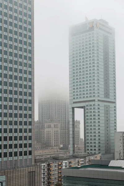 Beautiful modern foggy European city of Warsaw with office skyscrapers, business centers and a palace of culture with a fog. Urban cloudy day
