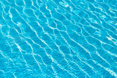 Amazing blue water texture in a pool with waves and ripples