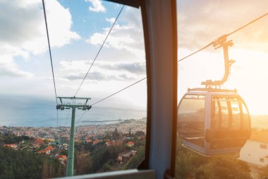 Beautiful view from the funicular to the vintage city of Funchal with orange roofs at sunset. Madeira volcanic island and ocean. Amazing view and cable car ride