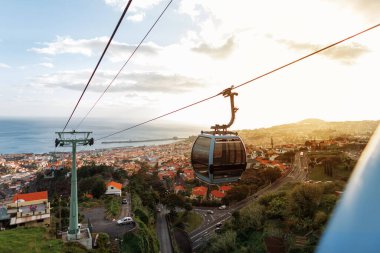 Beautiful landscape of the city of Funchal with cable cars, orange roofs and the ocean at sunset. Traveling on the island of Madeira