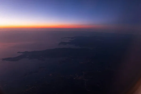 Amazing sky view from airplane porthole to sunset sky with European continent, Spain.