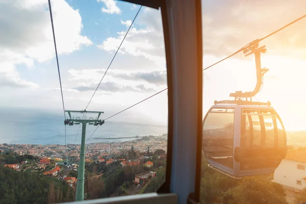 Beautiful view from the funicular to the vintage city of Funchal with orange roofs at sunset. Madeira volcanic island and ocean. Amazing view and cable car ride