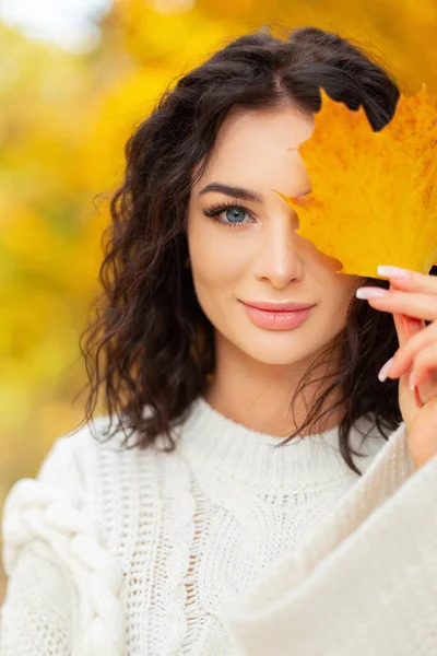 얼굴에 곱슬곱슬 머리와 아름다운 여성의 단풍나무 잎으로 얼굴을 유행하는 스웨터 — 스톡 사진