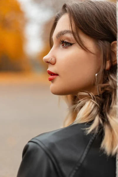 一个穿着时髦黑色皮夹克的年轻漂亮姑娘的女性秋天画像矗立在秋天的彩色公园里 — 图库照片