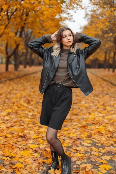 가을에 아가씨가 재킷을 스웨터 반바지 스타킹 부츠를 황금빛 가을노란 공원을 — 스톡 사진