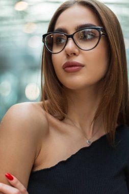 Modern cam ofis binasında klasik gözlükleri olan şık siyah bir bluzla şık, güzel, profesyonel bir yönetici kadın Kafkas modeli.