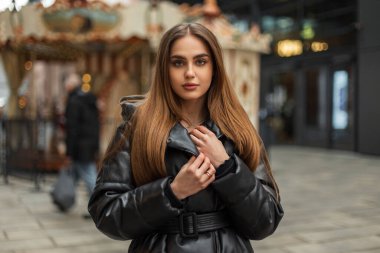 Güzel beyaz kadın portresi. Kışlık siyah montlu yeşil gözlü güzel beyaz kadın. Şehirde klasik bir parkta yürüyor.