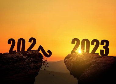 2023 yılbaşı gecesi gün batımında dağda, konsept. 2022 ve 2023 gündoğumunda uçurumun kenarında, yaratıcı bir fikir. 2022 sonsuzluğa düşer. Tasarım için boş alan
