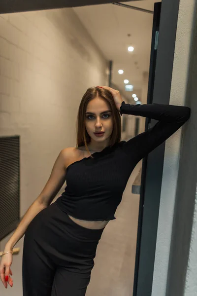 Modny Model Pięknej Kobiety Eleganckich Czarnych Ubraniach Stoi Pobliżu Drzwi — Zdjęcie stockowe