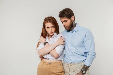 Moda kızı ve beyaz arka planda poz veren şık gündelik elbiseli bir adam.