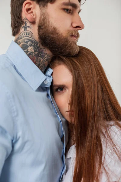 一个漂亮的时髦女人 红头发 和一个英俊的留着胡子的嬉皮士男人站在工作室里 背景是白色的 年轻貌美的夫妻 — 图库照片
