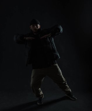 Siyah elbiseli, karanlıkta dans eden siluet dansçısı.