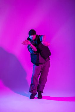 Havalı moda stili, modaya uygun siyah elbiseli profesyonel dansçı pembe ve neon ışıklı yaratıcı bir stüdyoda dans ediyor.