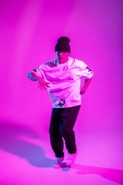 Profesyonel dansçı, pembe ve neon ışıklı yaratıcı bir stüdyoda dans ediyor. Break Dans