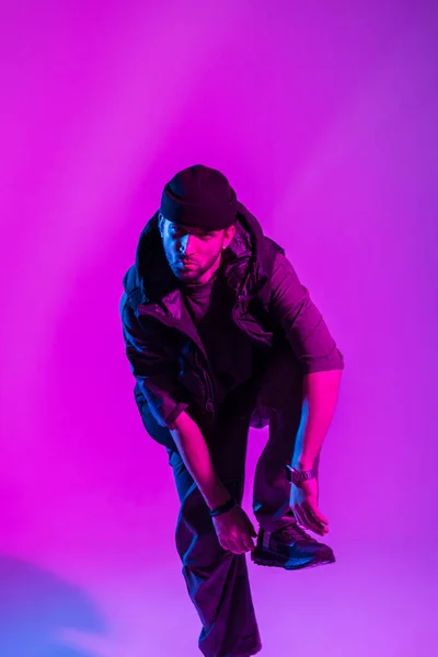 stock image Handsome professional dancer guy in fashionable clothes dancing in a creative studio with pink and neon lights