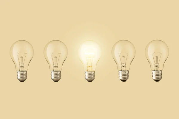 Electric light bulbs and one light bulb glows on a beige background. Think differently. Creative idea, concept