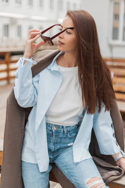 코트와 셔츠와 청바지를 빈티지 선글라스를 시내에 스타일의 평범하고 아름다운 아름다운 — 스톡 사진