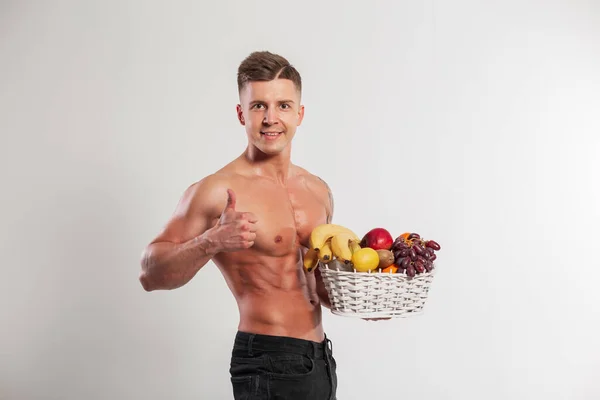 酷酷强壮的肌肉运动帅哥拿着果篮 在演播室的白色背景上表现得很像 健康的生食 水果和天然维生素 — 图库照片