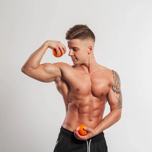 有发型 肌肉发达 拿着橙子 有二头肌的男人 — 图库照片