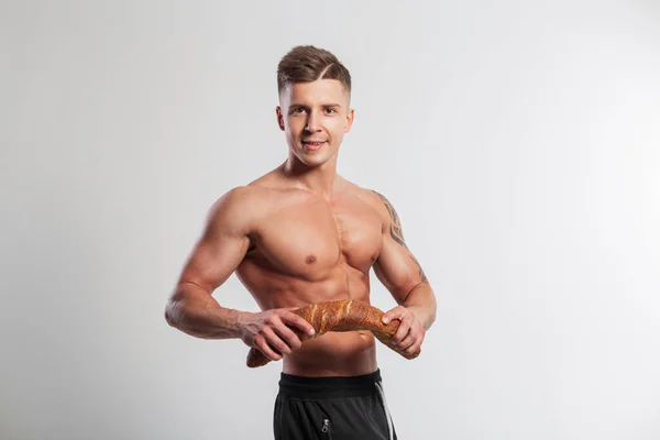 快乐英俊强壮的运动员适合一个有着肌肉身体的发型的人 在白色背景上打破了面包面包 健康食品和烘焙 — 图库照片