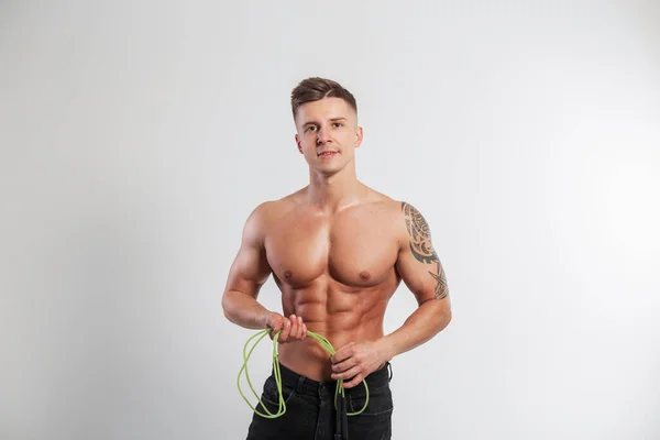 健康な裸の筋肉質の胴を持つクールなハンサムな筋肉の男は スタジオで白い背景にジャンプロープを保持しています アクティブなライフスタイル トレーニング — ストック写真