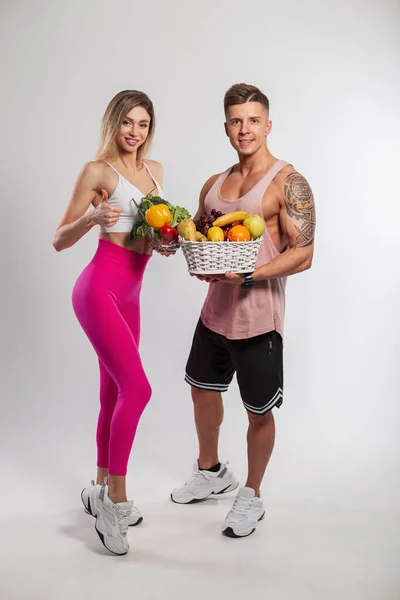 Piękna Szczupła Dziewczyna Fitness Przystojny Atletyczny Muskularny Mężczyzna Trzyma Owoce — Zdjęcie stockowe