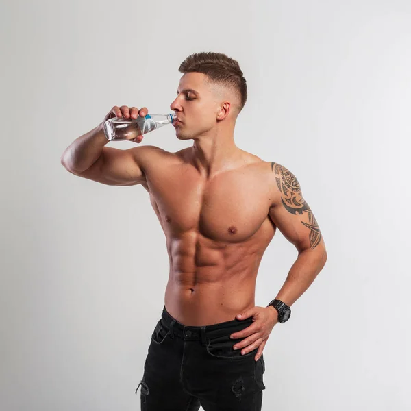 白い背景にガラスの水を飲む筋肉の体を持つハンサムなスポーツフィットネスの男 スポーツ 健康と水のバランス — ストック写真