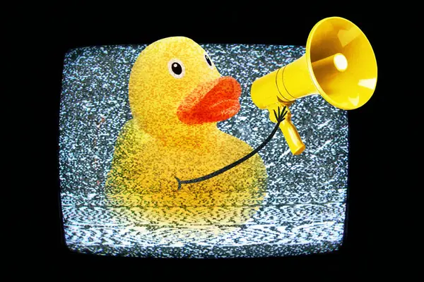 Creative yellow duck screams in a yellow loudspeaker from TV with white noise, concept. Media and video advertising, creative idea. Successful propaganda. Mass media