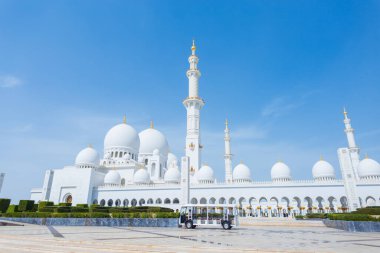 Şeyh Zayed Büyük Cami Merkezi. Güneşli bir günde Abu Dabi 'de minibüsü olan güzel bir cami.
