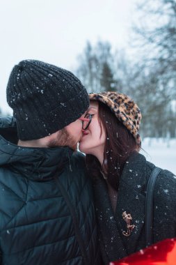 Moda kıyafetleri içinde parkta öpüşen güzel genç aşıklar.