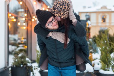 Güzel aşıklar şehirde sokakta birlikte eğleniyor ve eğleniyorlar. Yakışıklı bir adam sırtında bir kız taşır, kadın adamı yanağından öper.