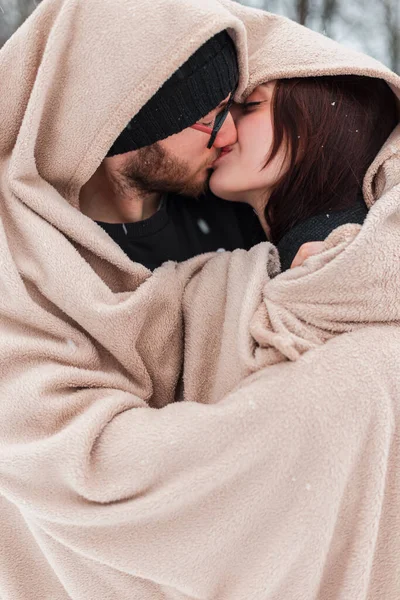 Genç moda güzel mutlu aşıklar bej renkli ekose bir parkta karla öpüşüyor. Sevgililer Günü
