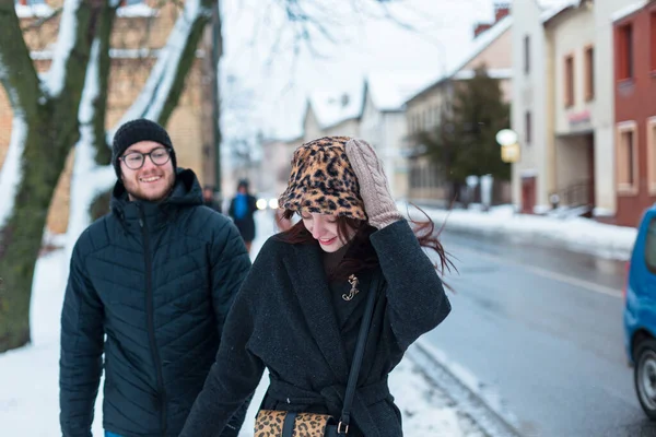 Güzel genç bir kadın ve şık giyinmiş yakışıklı bir adam el ele yürüyorlar ve şehirde eğleniyorlar. Sokakta bir çift güzel aşık