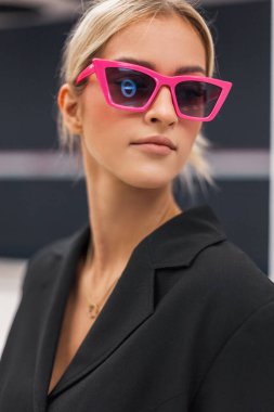 Siyah ceketli, pembe güneş gözlüklü, havalı moda kadını mankeni.