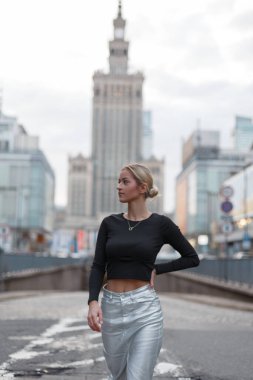 Moda kıyafetleri içinde, şehirde etek ve etek yürüyüşleri yapan güzel bir genç kadın. Güzel, şık bir bayan.