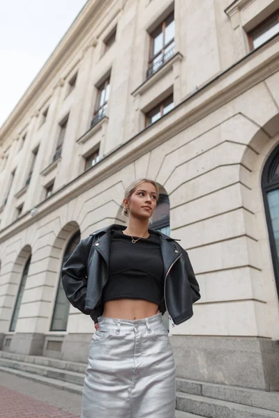 Moda kıyafetleri içinde, şehirde etekli siyah ceketli güzel bir kadın manken.