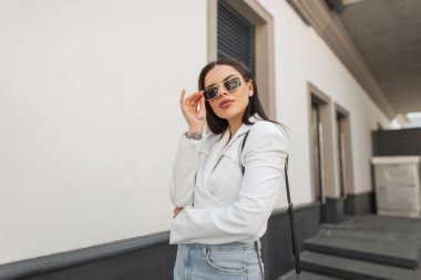 Moda mankeni, modaya uygun bir güneş gözlüğü ve sokakta kot pantolon giyiyor.