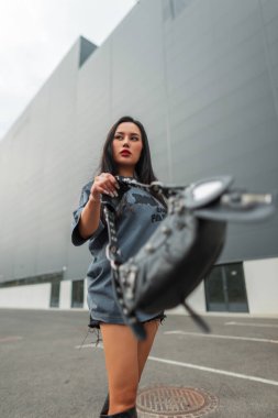 Havalı, başarılı, kendine güveni olan, şehirde moda çantalı, şık şehir kıyafetleriyle dolaşan güzel bir Asyalı kadın.