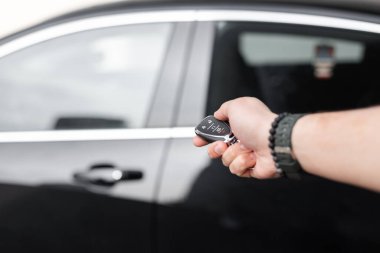 Adamın eli arabanın anahtarlarını tutuyor. Bir araba kirala. Test sürüşü Ulaşım satın alınması