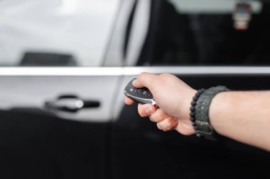 Adam anahtarları tutar ve arabayı açar. Araba kiralama ve test sürüşü