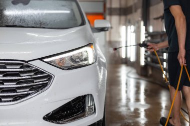 Farlı beyaz SUV arabası oto yıkamada yıkandı.