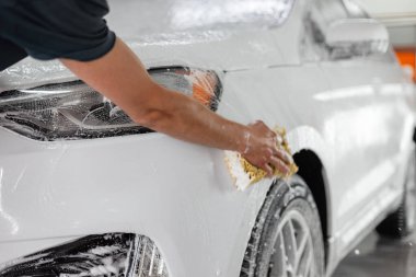 Süngerli erkek eller araba yıkamada araba yıkar. Araba bakımı ve temizlik