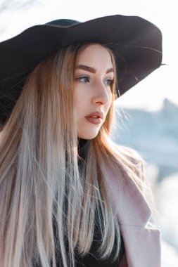 Açık havada siyah şapkalı zarif bir kadının kış portresi.