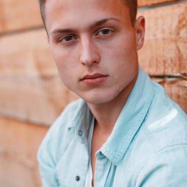 Çilli kot elbiseli yakışıklı bir gencin yakın plan portresi.